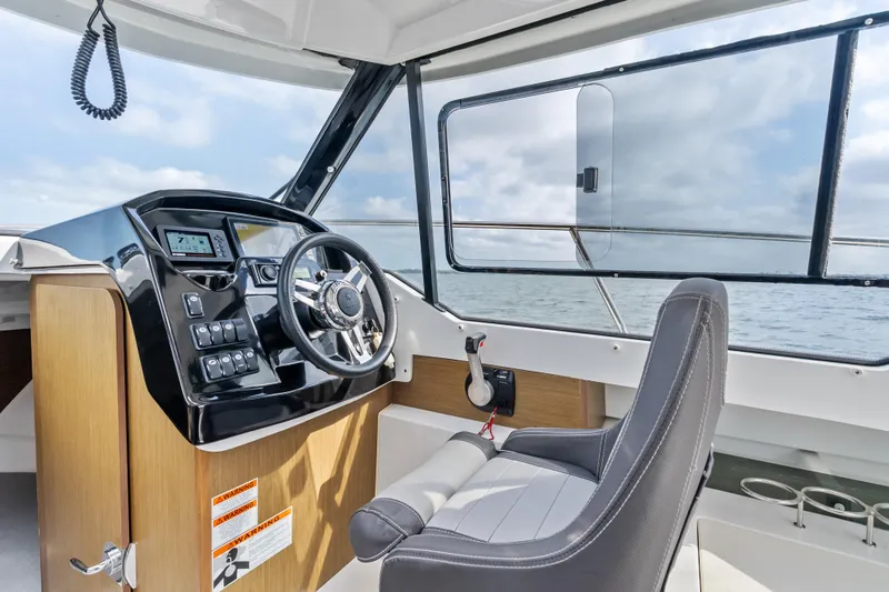 Slide: The Image of Interior view of 2020 Jeanneau NC 795 boat cockpit with steering wheel and controls. - 14