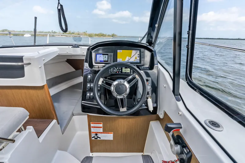 Slide: The Image of Cockpit of 2020 Jeanneau NC 795 boat with steering wheel and navigation system. - 15