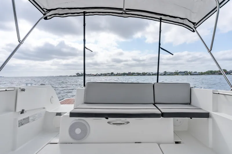 Slide: The Image of Jeanneau NC 795 boat interior with cushioned seating, overlooking calm waters, 2020 model. - 17