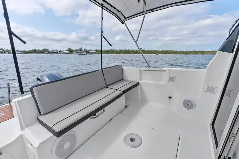 Slide: The Image of 2020 Jeanneau NC 795 boat interior with cushioned seating and water view. - 18