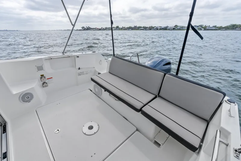 Slide: The Image of 2020 Jeanneau NC 795 boat deck with cushioned seating, overlooking calm waters. - 19