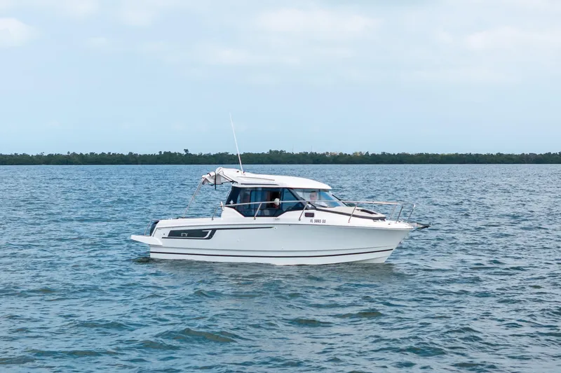 Slide: The Image of 2020 Jeanneau NC 795 boat cruising on open water under a cloudy sky. - 2