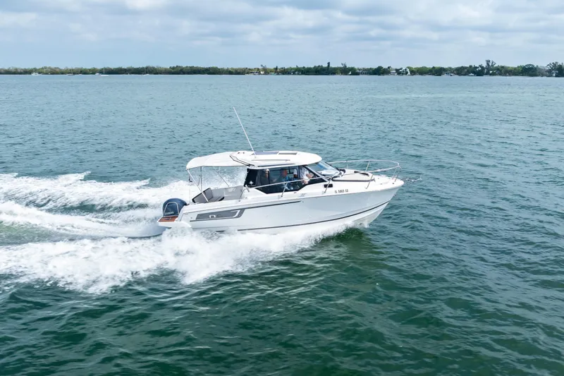 Slide: The Image of 2020 Jeanneau NC 795 motorboat cruising on open water under a cloudy sky. - 5