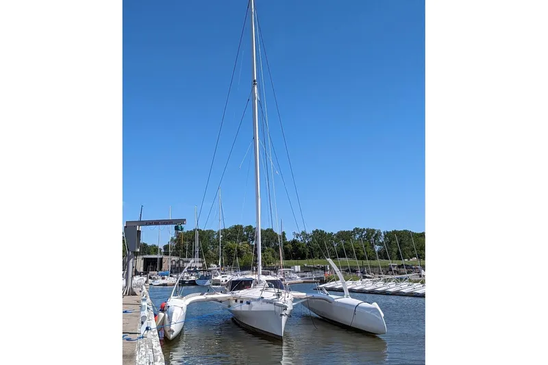 Slide: The Image of 2023 Rapido 40 trimaran docked at a marina under clear blue skies. - 2