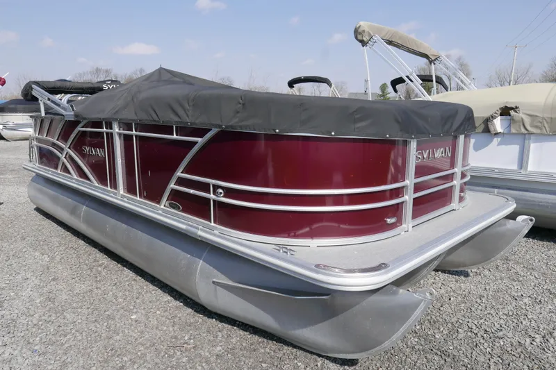 Slide: The Image of 2021 Sylvan Mirage 8520 Cruise pontoon boat with maroon exterior and protective cover. - 12