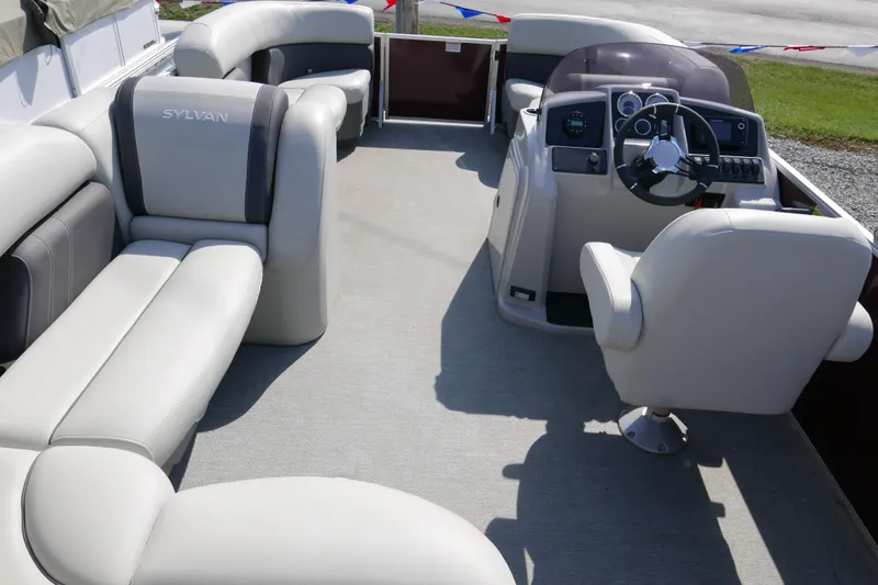 Slide: The Image of 2021 Sylvan Mirage 8520 Cruise pontoon boat interior with plush seating and steering console. - 9