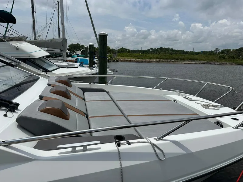 Slide: The Image of 2021 Beneteau GT 32 yacht docked, featuring sleek design and spacious sunbathing area. - 10