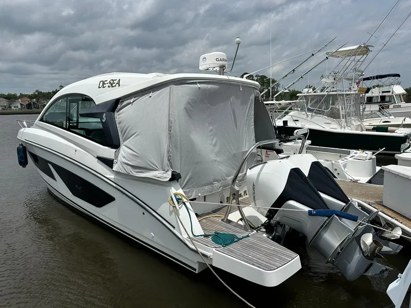 Slide: The Image of 2021 Beneteau GT 32 boat docked, covered stern, overcast sky, marina setting. - 2
