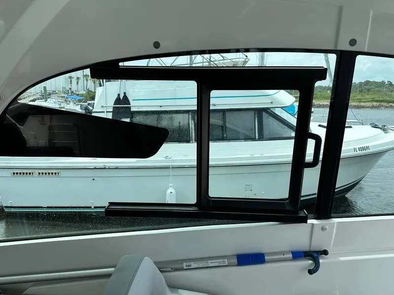 Slide: The Image of 2021 Beneteau GT 32 interior view with window overlooking docked boat. - 23