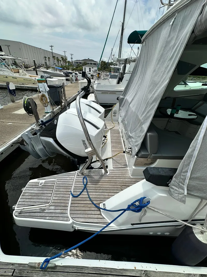 Slide: The Image of 2021 Beneteau GT 32 docked, showcasing rear deck and outboard motor. - 6