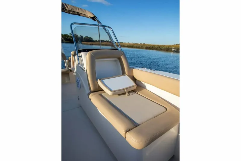 Slide: The Image of Manufacturer Provided Image: 2025 Scout 195 Sport Dorado boat interior with beige seating by the water. - 6
