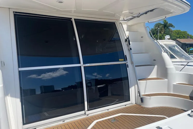 Slide: The Image of 2000 Cruisers Yachts 5000 Sedan Sport with sleek glass doors and elegant wooden steps. - 6