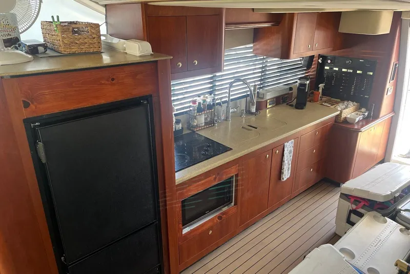 Slide: The Image of Luxurious kitchen interior of 2000 Cruisers Yachts 5000 Sedan Sport with wooden cabinetry. - 8