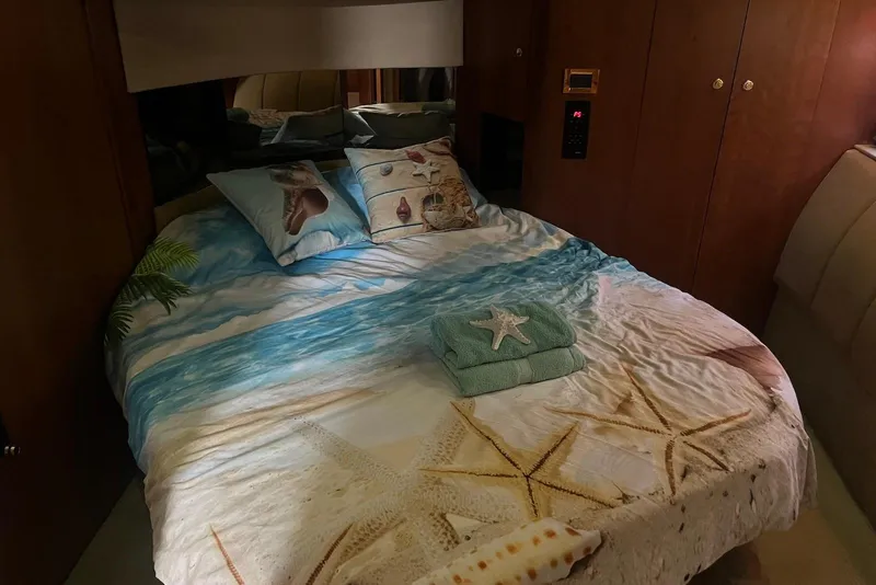 Slide: The Image of Cozy bedroom in 2000 Cruisers Yachts 5000 Sedan Sport with beach-themed bedding. - 9