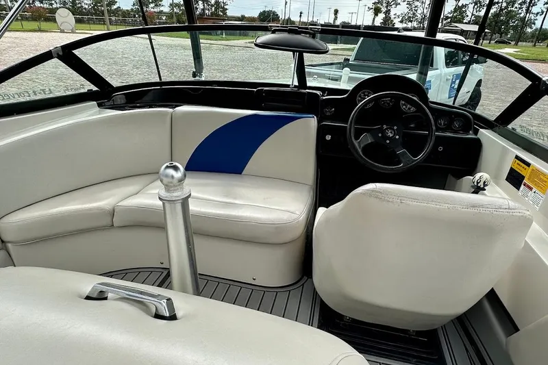 Slide: The Image of Interior of a 1998 MasterCraft SportStar 19 boat with white seating and steering wheel. - 21