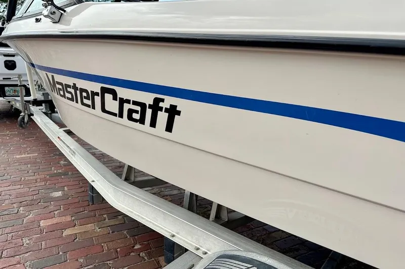 Slide: The Image of 1998 MasterCraft SportStar 19 boat on trailer, featuring blue stripe and logo. - 6