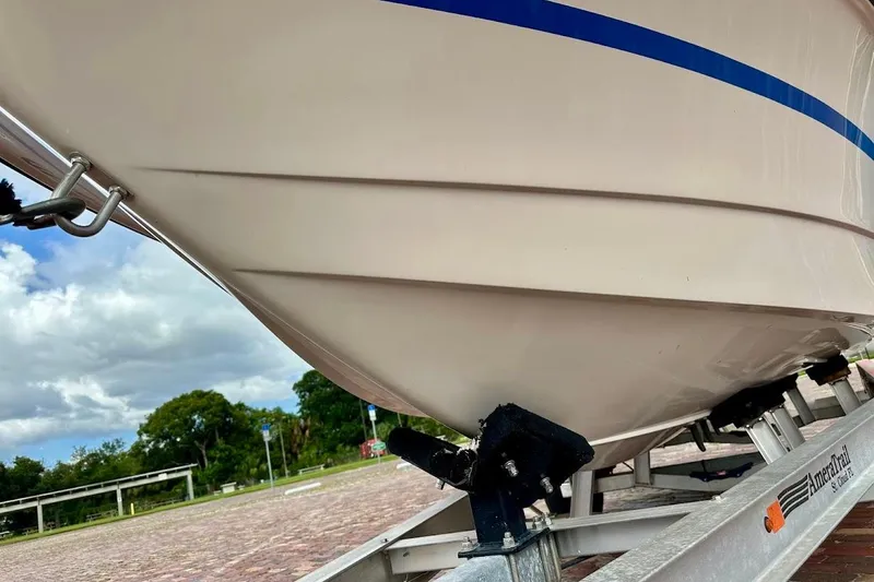 Slide: The Image of 1998 MasterCraft SportStar 19 boat on trailer, showcasing hull design and blue stripe. - 8