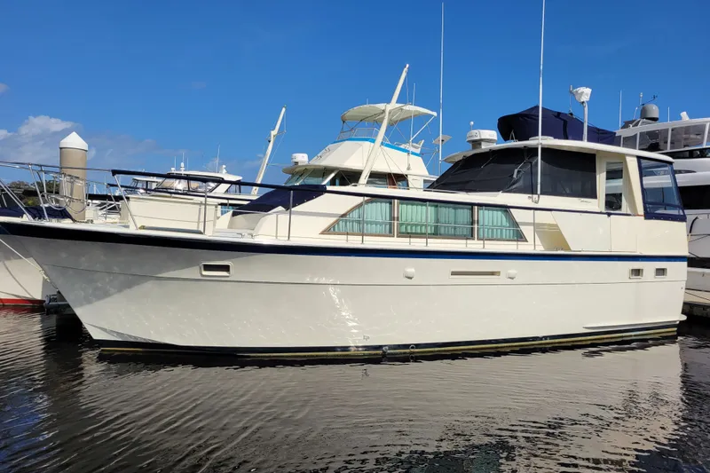 The Image of 1977 Hatteras 43 Double Cabin yacht docked at marina under clear blue sky. - 0