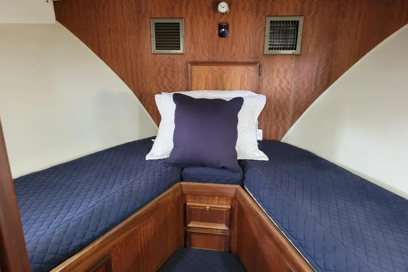 Slide: The Image of Cozy cabin interior of 1977 Hatteras 43 Double Cabin with blue bedding and wood paneling. - 12