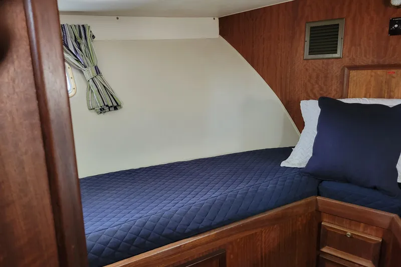 Slide: The Image of 1977 Hatteras 43 Double Cabin interior with blue bedding and wooden accents. - 14