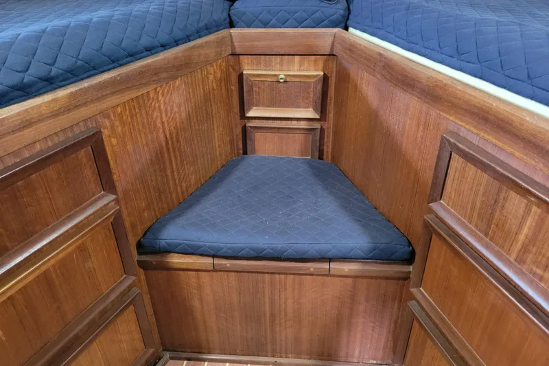 Slide: The Image of 1977 Hatteras 43 Double Cabin interior with wood paneling and blue cushioned seating. - 15