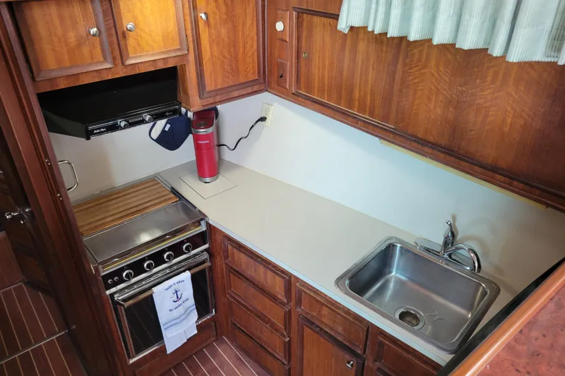 Slide: The Image of 1977 Hatteras 43 Double Cabin kitchen with wood cabinets, stove, and sink. - 18