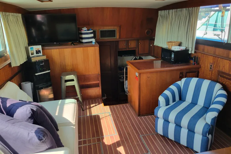 Slide: The Image of Interior of 1977 Hatteras 43 Double Cabin with striped chair and wooden decor. - 2