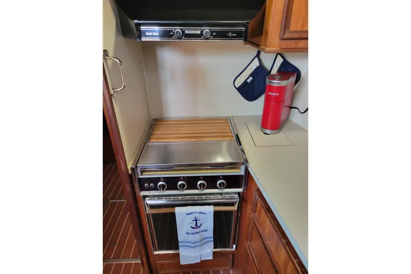 Slide: The Image of 1977 Hatteras 43 Double Cabin kitchen with stove, oven, and red coffee maker. - 21