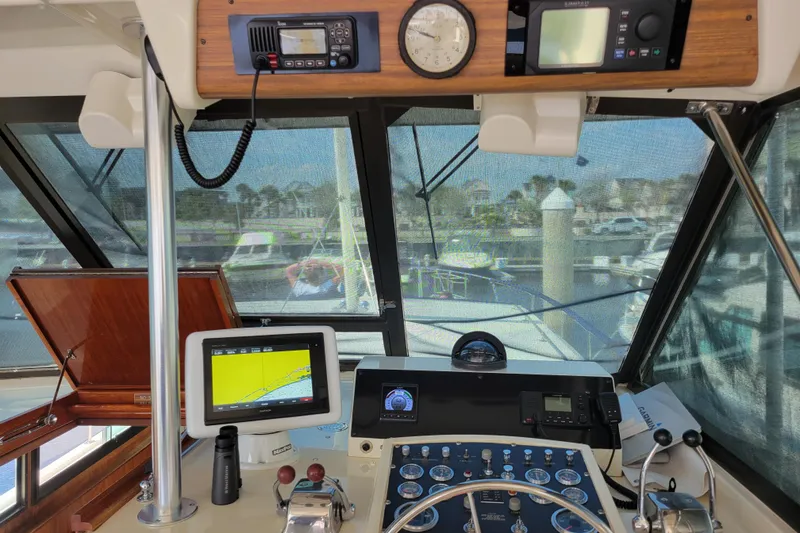 Slide: The Image of 1977 Hatteras 43 Double Cabin helm with navigation equipment and marina view. - 26