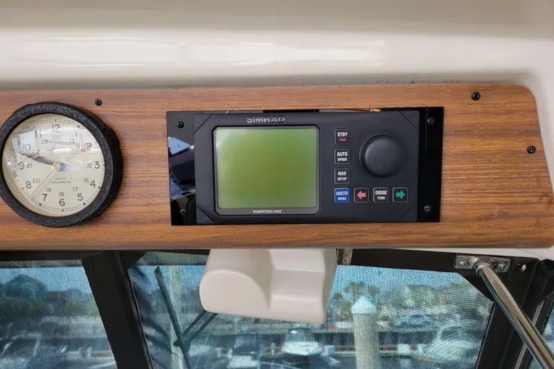 Slide: The Image of 1977 Hatteras 43 Double Cabin dashboard with clock and Simrad navigation system. - 28