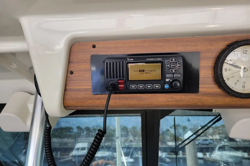 Slide: The Image of 1977 Hatteras 43 Double Cabin radio and clock on wooden panel. - 29
