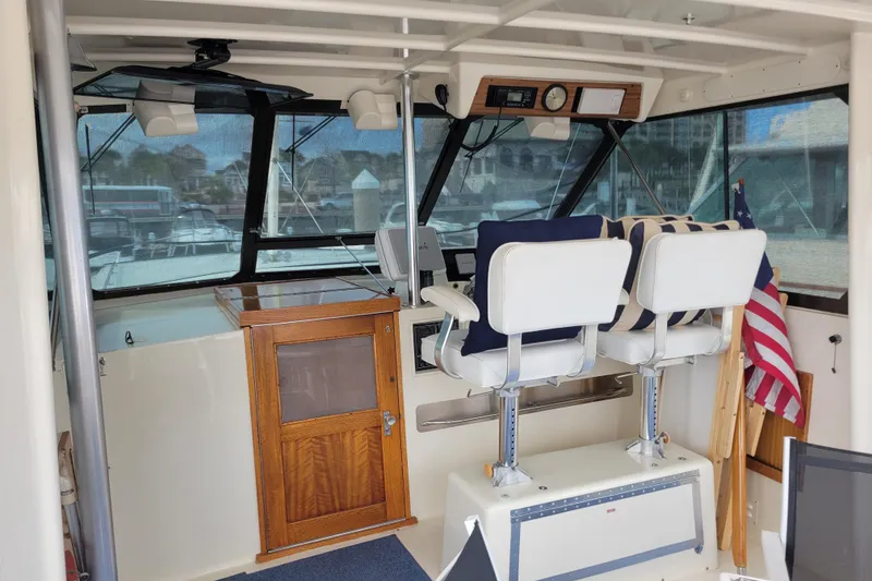Slide: The Image of 1977 Hatteras 43 Double Cabin helm with white seats and American flag. - 31