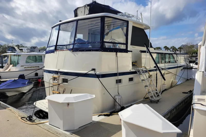 Slide: The Image of 1977 Hatteras 43 Double Cabin yacht docked at marina under cloudy sky. - 35