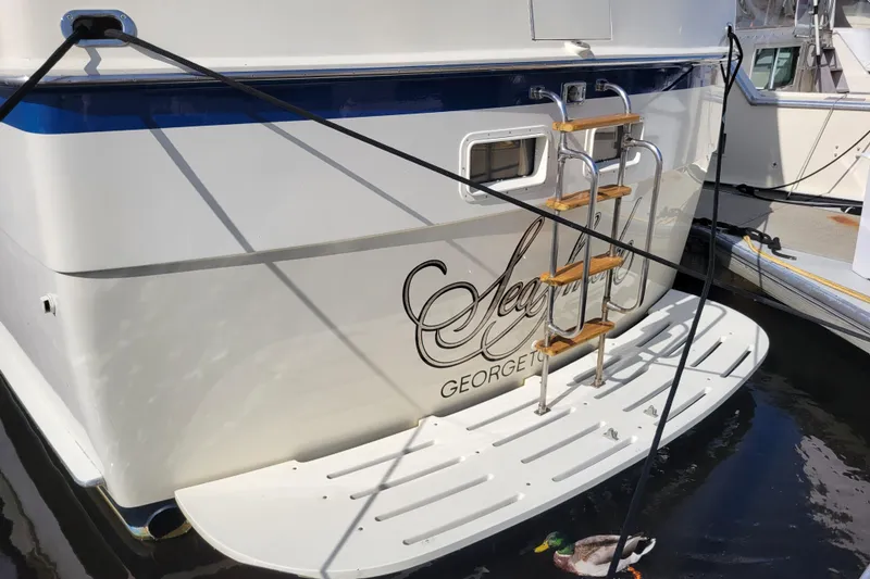 Slide: The Image of 1977 Hatteras 43 Double Cabin yacht stern with ladder and duck in water. - 39