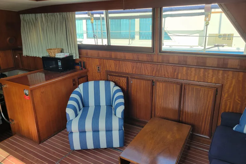Slide: The Image of Interior of 1977 Hatteras 43 Double Cabin with wood paneling and striped chair. - 4