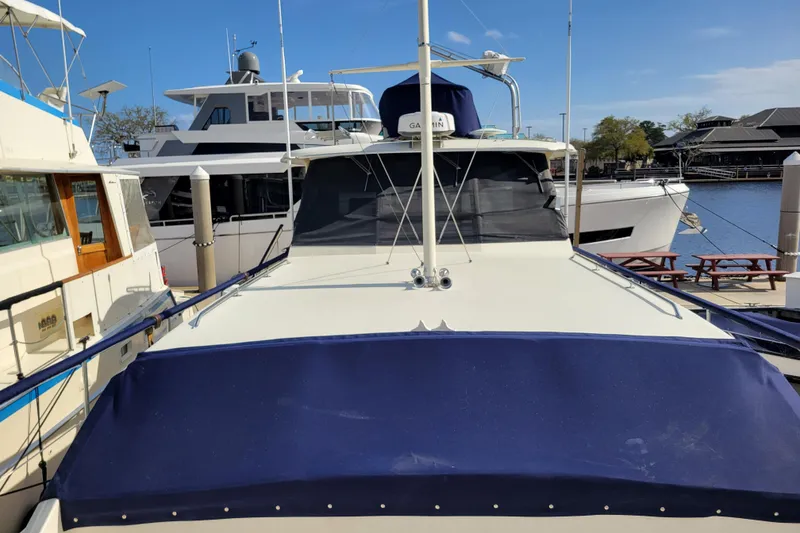 Slide: The Image of 1977 Hatteras 43 Double Cabin yacht docked at marina under clear blue sky. - 43