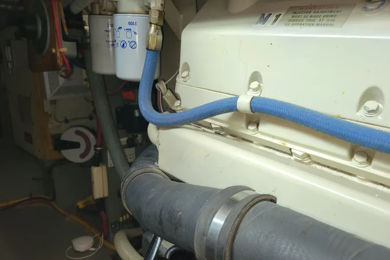 Slide: The Image of Engine room of 1977 Hatteras 43 Double Cabin with visible hoses and filter. - 50