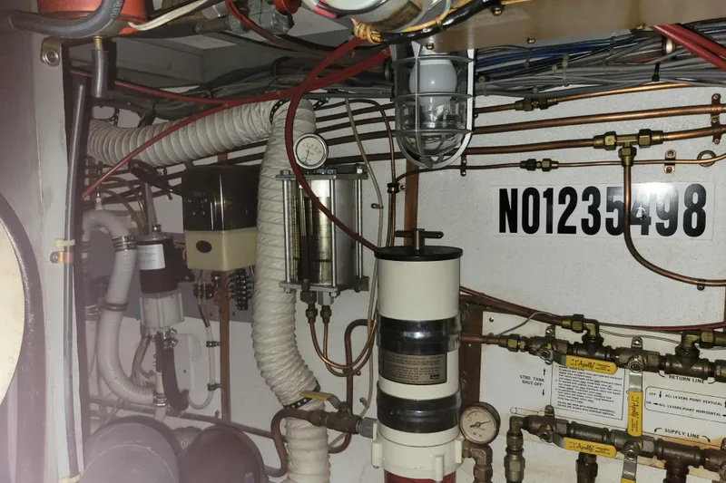 Slide: The Image of Engine room of a 1977 Hatteras 43 Double Cabin with visible pipes and gauges. - 51