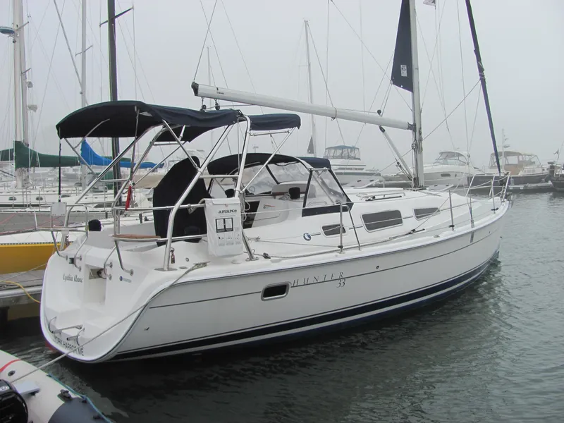 The Image of 2008 Hunter 33 sailboat docked in harbor, featuring Bimini top. - 0