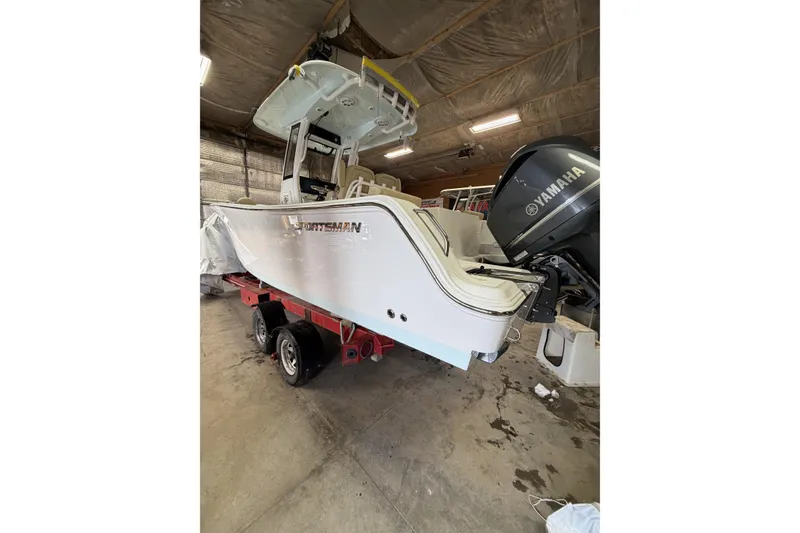 Slide: The Image of 2026 Sportsman Heritage 231 Center Console boat with Yamaha engine in a garage setting. - 2