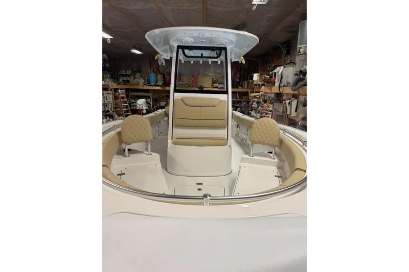 Slide: The Image of 2026 Sportsman Heritage 231 Center Console boat interior with tan seating in a workshop. - 5