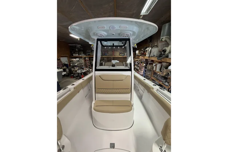 Slide: The Image of 2026 Sportsman Heritage 231 Center Console boat interior with tan seating and modern design. - 6