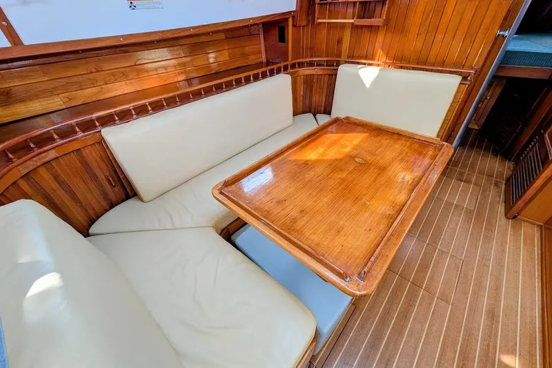 Slide: The Image of Interior of 1980 Island Trader 38 sailboat with wooden table and cushioned seating. - 10