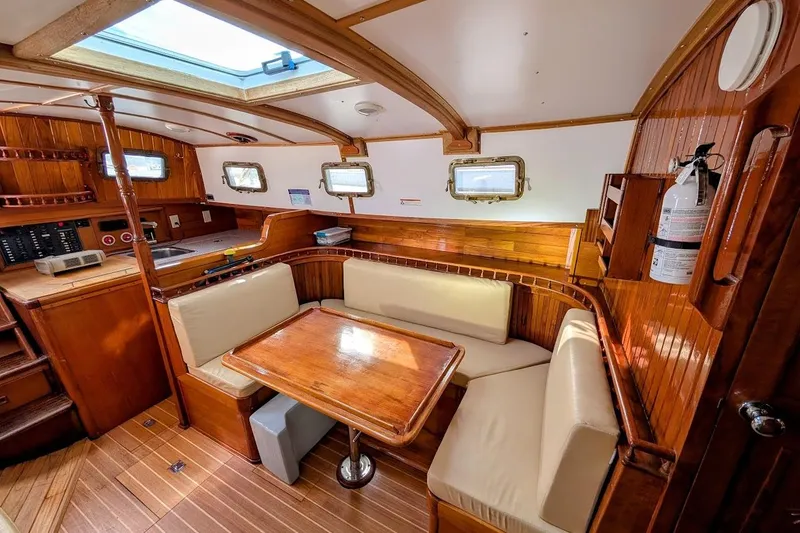 Slide: The Image of Interior of 1980 Island Trader 38 sailboat with wooden furnishings and cozy seating area. - 11