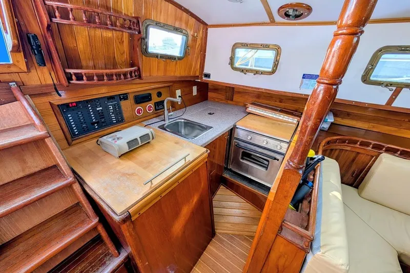 Slide: The Image of Interior of 1980 Island Trader 38 sailboat with wooden cabinetry and compact kitchen area. - 12