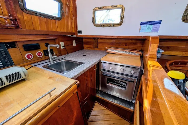 Slide: The Image of 1980 Island Trader 38 yacht kitchen with wooden cabinetry, sink, and stove. - 13