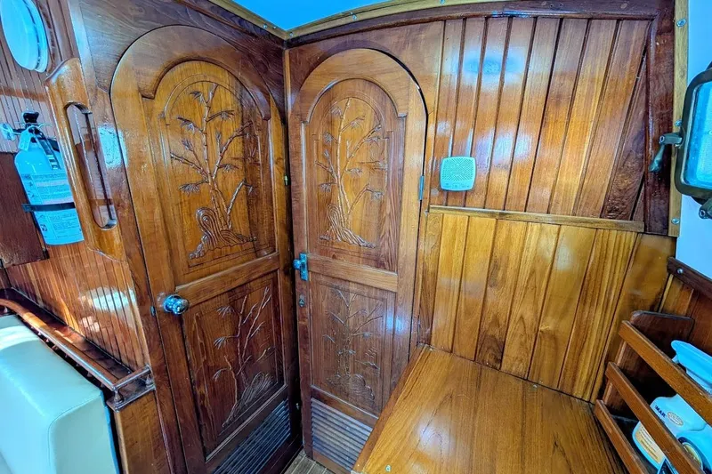 Slide: The Image of Interior of 1980 Island Trader 38 with carved wooden doors and nautical decor. - 15