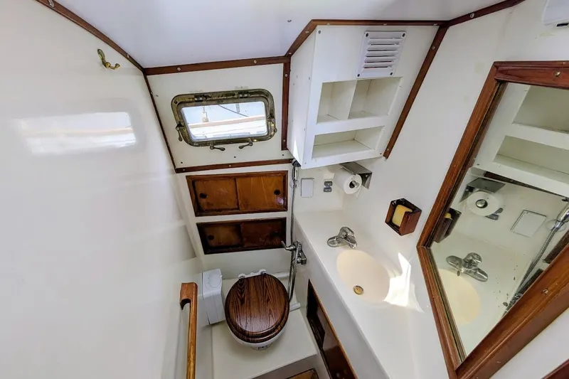 Slide: The Image of Compact bathroom in 1980 Island Trader 38 yacht with wooden accents and porthole window. - 16
