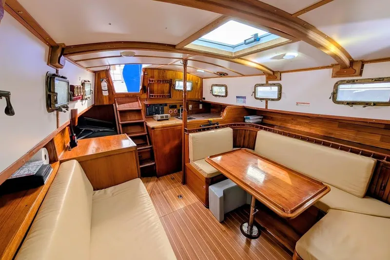 Slide: The Image of Interior of 1980 Island Trader 38 sailboat with wooden furnishings and cozy seating area. - 17