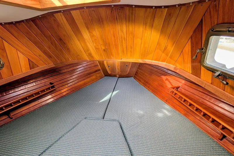 Slide: The Image of Interior of 1980 Island Trader 38 sailboat with wooden paneling and cozy sleeping area. - 19